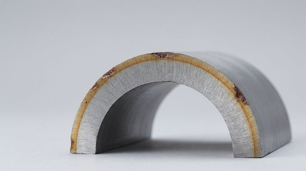 Corte transversal de parede de vaso de pressão em aço, com a parcela externa da espessura destacada como reserva de corrosão sendo consumida por pites.