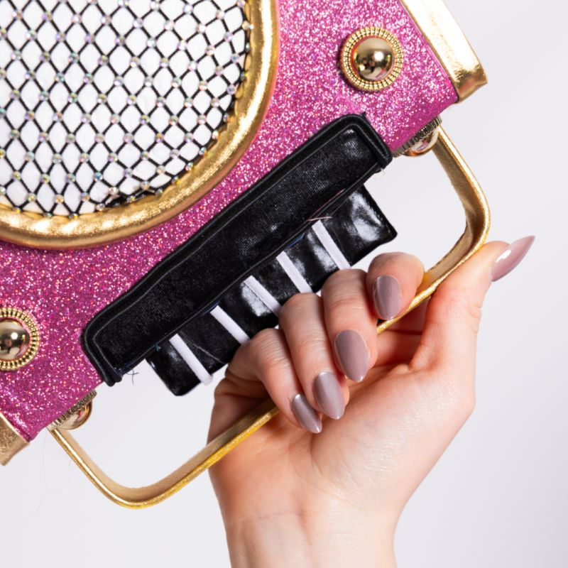 Hand met Glazed & Unbothered glazed taupe press-on nagels en roze keyboard-accessoire.