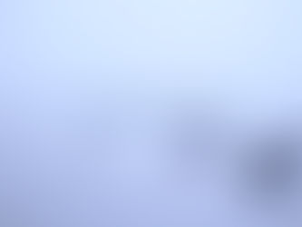 small boats moored in calm water and small fog shrouded island
