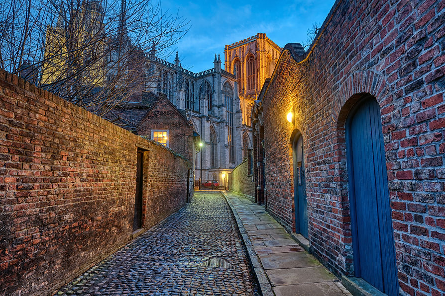 Small cobbled alleyway in York at night with the famous Minster in the back.jpg