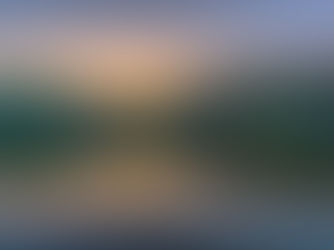 Chattahoochee River reflects a serene sunset, with silhouetted trees along the water's edge and a vibrant sky of orange and blue hues.