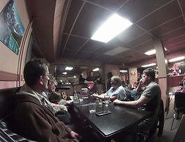People sitting at a table in a dimly lit bar