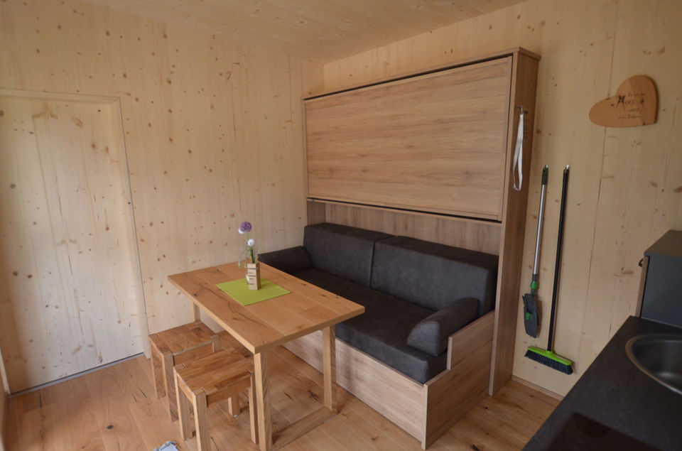Kompakte Wohnlandschaft mit Wandbett und Tisch