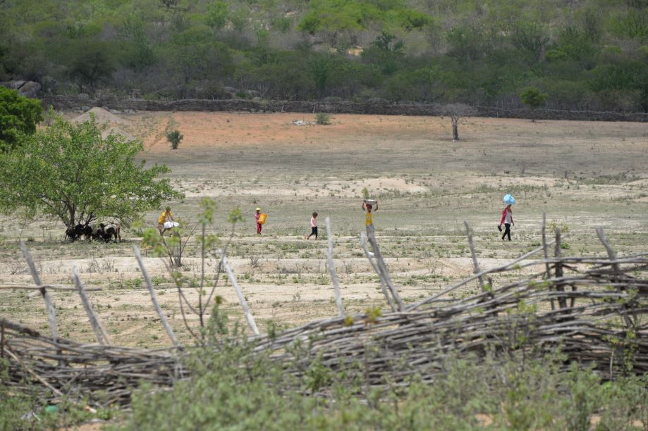 Foto: Família lavando roupa no barreiro (crédito: Getulio Nascimento)