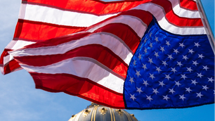 An American flag flies upside down above San Francisco City Hall on April 5 as protestors nationwide took to the streets to denounce the policies of President Donald Trump. (Credit: Peter Schurmann)