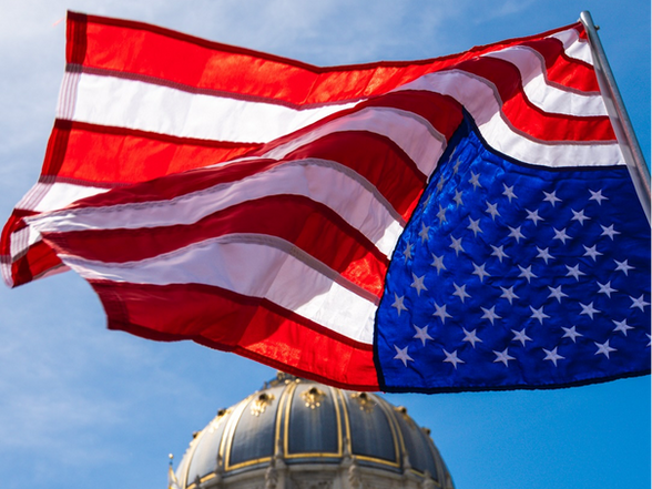 An American flag flies upside down above San Francisco City Hall on April 5 as protestors nationwide took to the streets to denounce the policies of President Donald Trump. (Credit: Peter Schurmann)