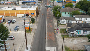 An aerial view of Canal Street in Houston, looking west, on July 12, 2026. Center right, opposite the strip mall, is a memorial to Lorenzo Salgado Araujo, who was was fatally shot by an immigration agent on July 7. Jon Shapley for The Texas Tribune