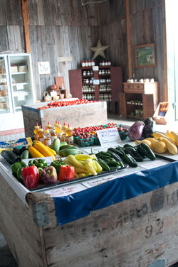 table in our market with local vegetables and honey for sale