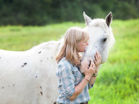 Marie Josée avec Apache, cheval-guide Appaloosa, dans un champ à la Ferme Lombrette.