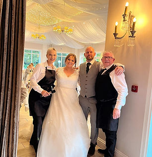 A bride and groom get a photograph with singing waiters