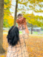 Mother holding baby with leaves in background