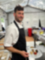 A man in chef uniform stands in a kitchen