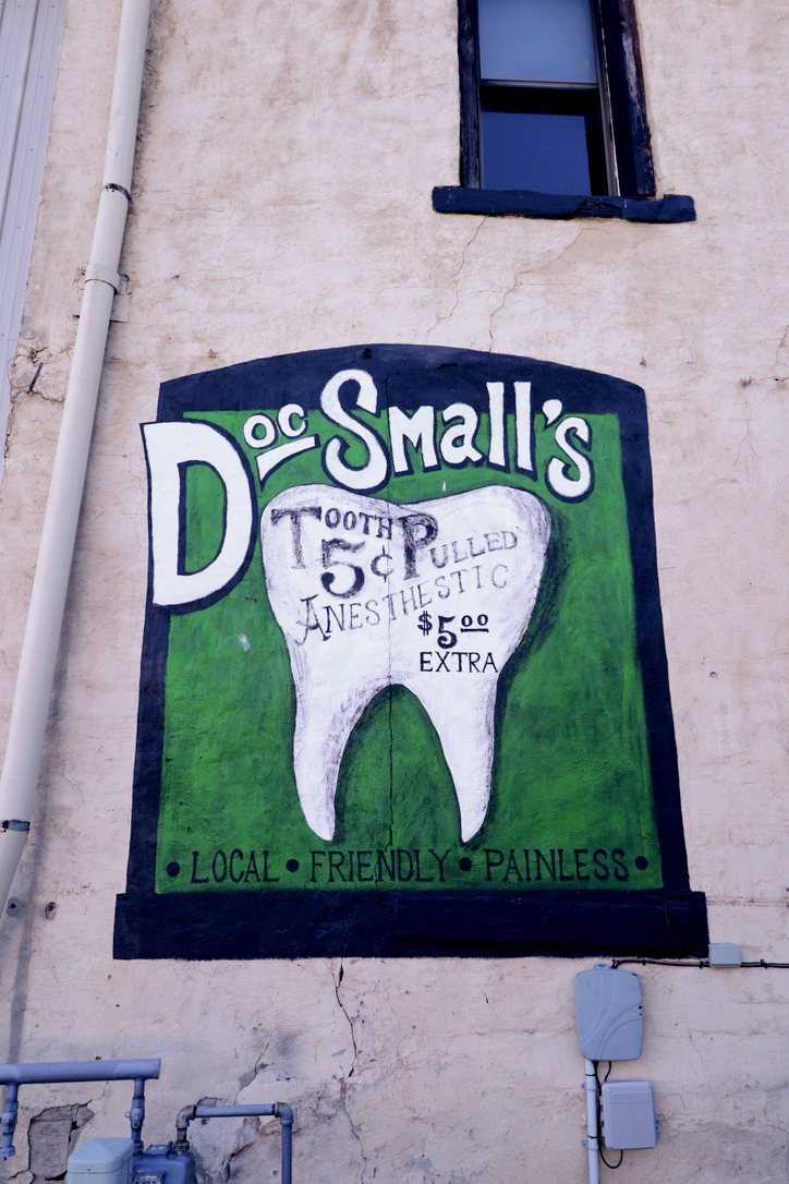 Dr. Small's Dentist sign on a building with tooth graphic.
