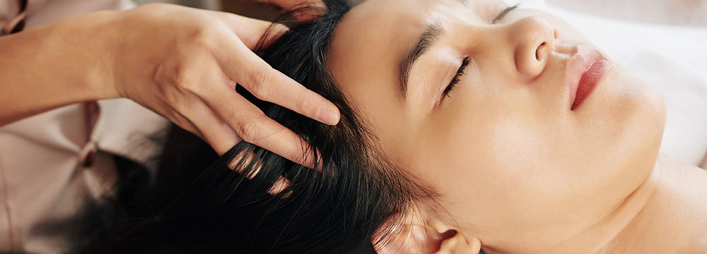 Woman receiving a relaxing head massage for ASMR relief