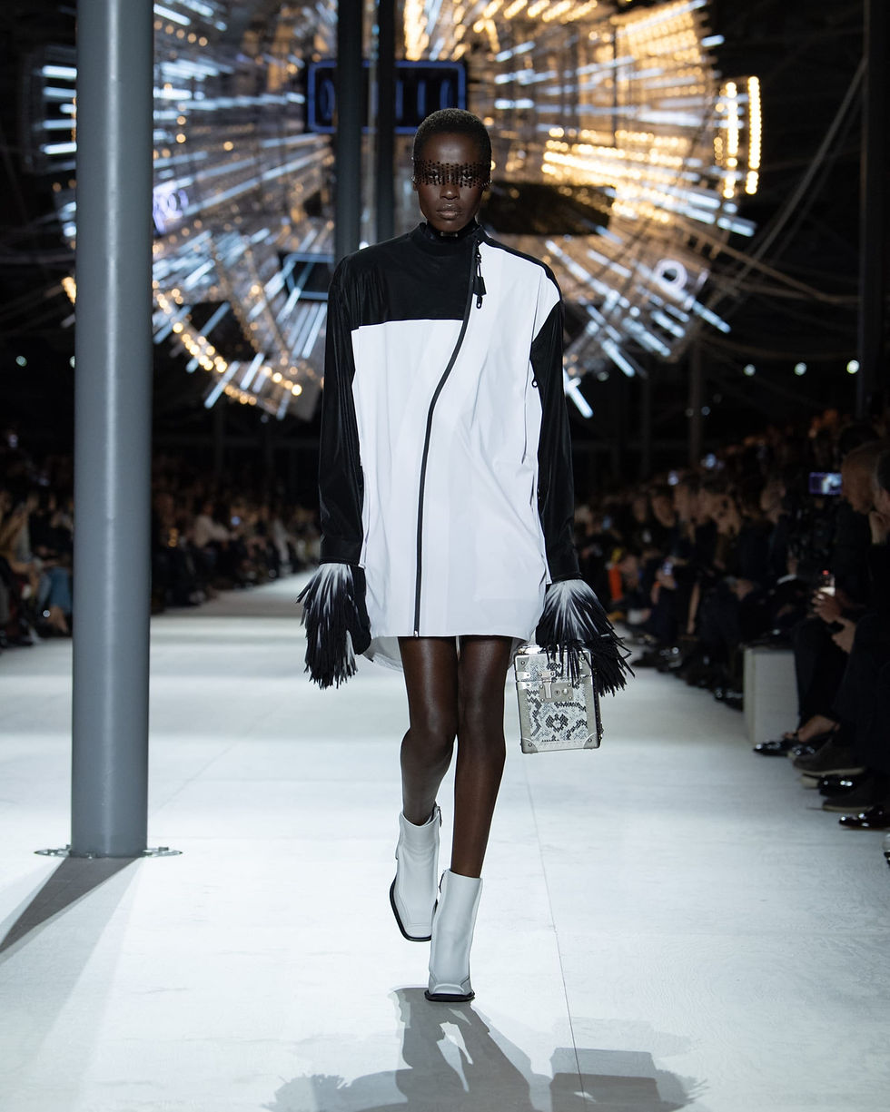 Louis Vuitton Women's Fall/Winter 2024: black-and-white sleeveless minidress with black gloves and pale ankle boots.