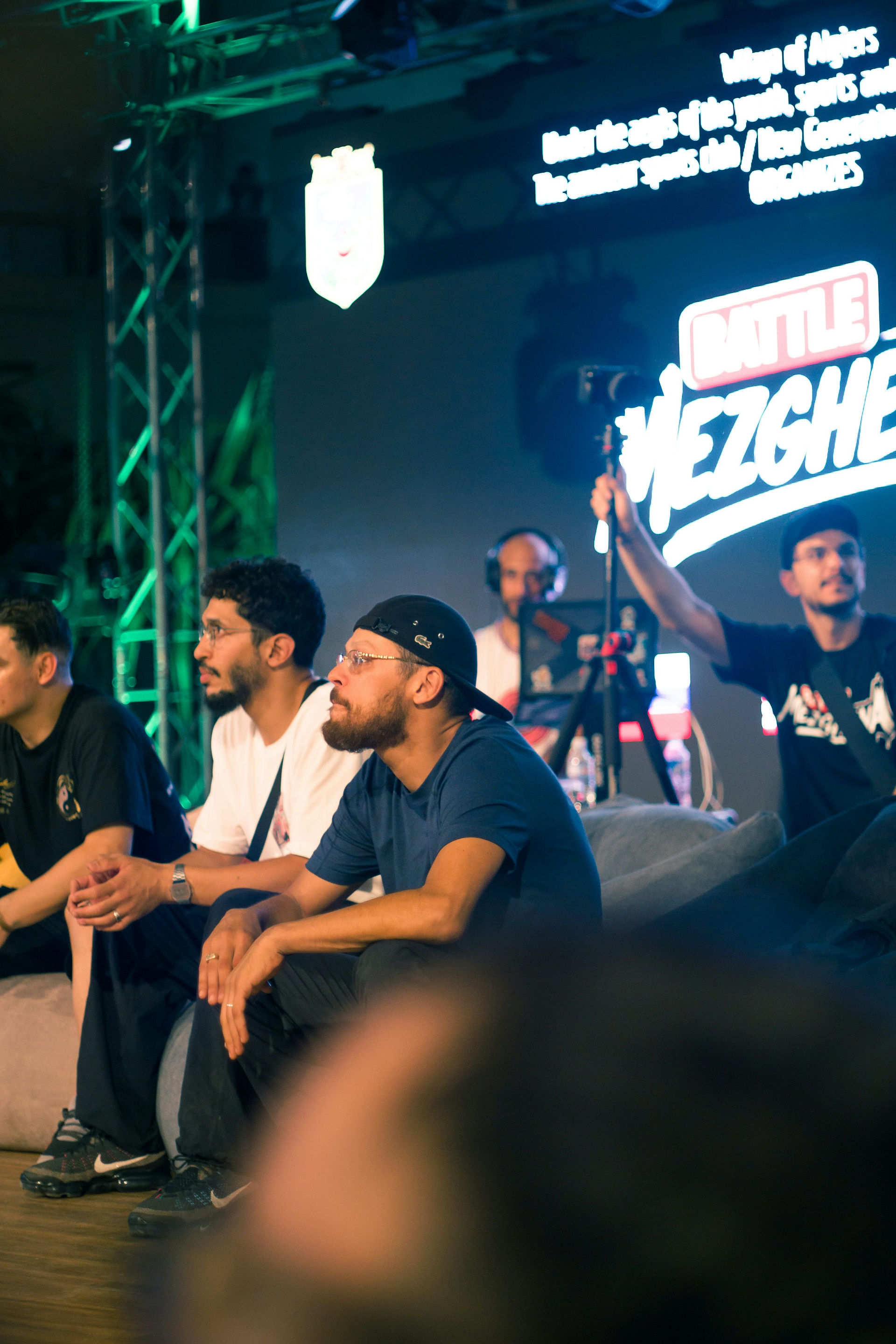 Spectators sit beside an event stage during a gaming competition.