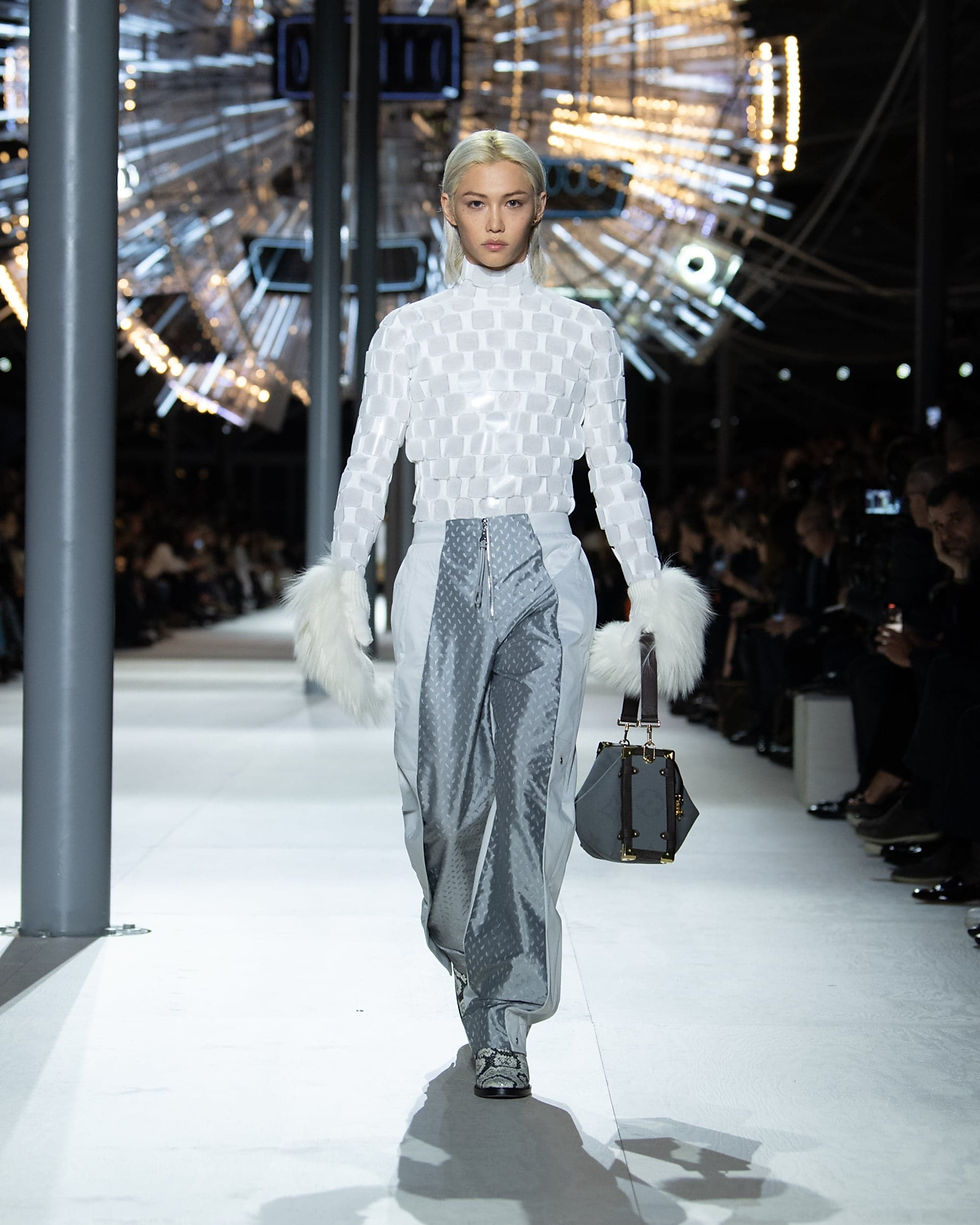 Louis Vuitton Women's Fall/Winter 2024: white textured top with silver panelled trousers, pale gloves and a dark handbag.