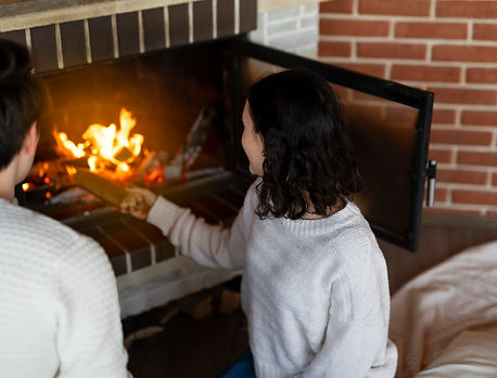 A couple beside a fireplace