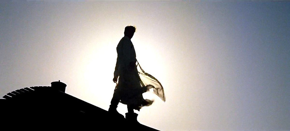 Peter O'Toole standing on a train white robes flying in classic film "Lawrence of Arabia" epic movie