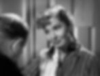 Woman in striped pajamas smiles gently at a man with a bowed head in a dimly lit room. The atmosphere is calm and intimate. Jean Arthur tells Charles Coburn the morning routine in the classic Hollywood romantic comedy film rom-com movie 1940s "The More the Merrier".
