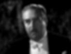 Man in formal wear with a white bow tie, looking serious. The black-and-white image has a dark, indistinct background. Walter Connolly co-stars in the Hollywood film screwball 1930s comedy classic movie “Libeled Lady”