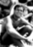 Man sitting on a beach in swim trunks, smiling and looking up. Other people in the blurred background, creating a relaxed, sunny vibe. Candid photo of classic Hollywood movie star film Western actor romantic comedy heartthrob young shirtless Joel McCrea
