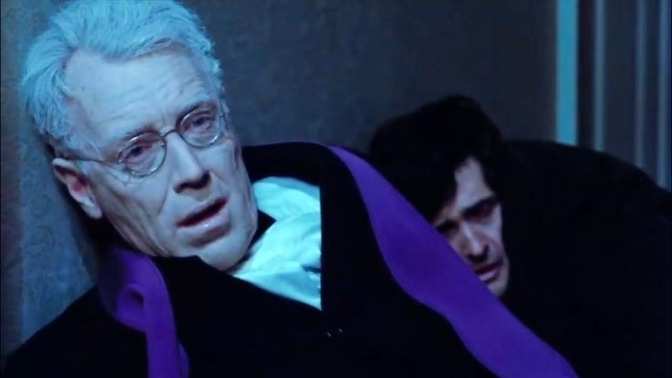 Two men in dark coats, one older with glasses and white hair, huddle in a dim blue room with purple accents, looking tense. Max von Sydow and Jason Miller in the scariest movie of all time, classic horror film about the devil and possession, 1973 "The Exorcist".