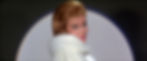 Woman in elegant white fur coat smiles over her shoulder under spotlight. Soft lighting and dark background create a glamorous mood. Ann-Margret sings "Appreciation" in the classic 1960s Elvis Presley rocking MGM movie musical "Viva Las Vegas".