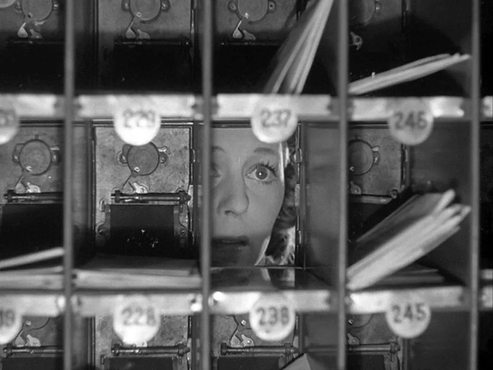Margaret Sullavan peers through an empty mailbox in the classic Ernst Lubitsch movie Hollywood romantic comedy film "The Shop Around the Corner"