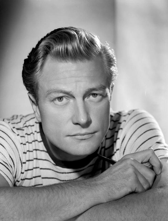Portrait photo of handsome Hollywood film and TV actor science fiction horror movie star young Richard Denning in striped short sleeved shirt crossing arms
