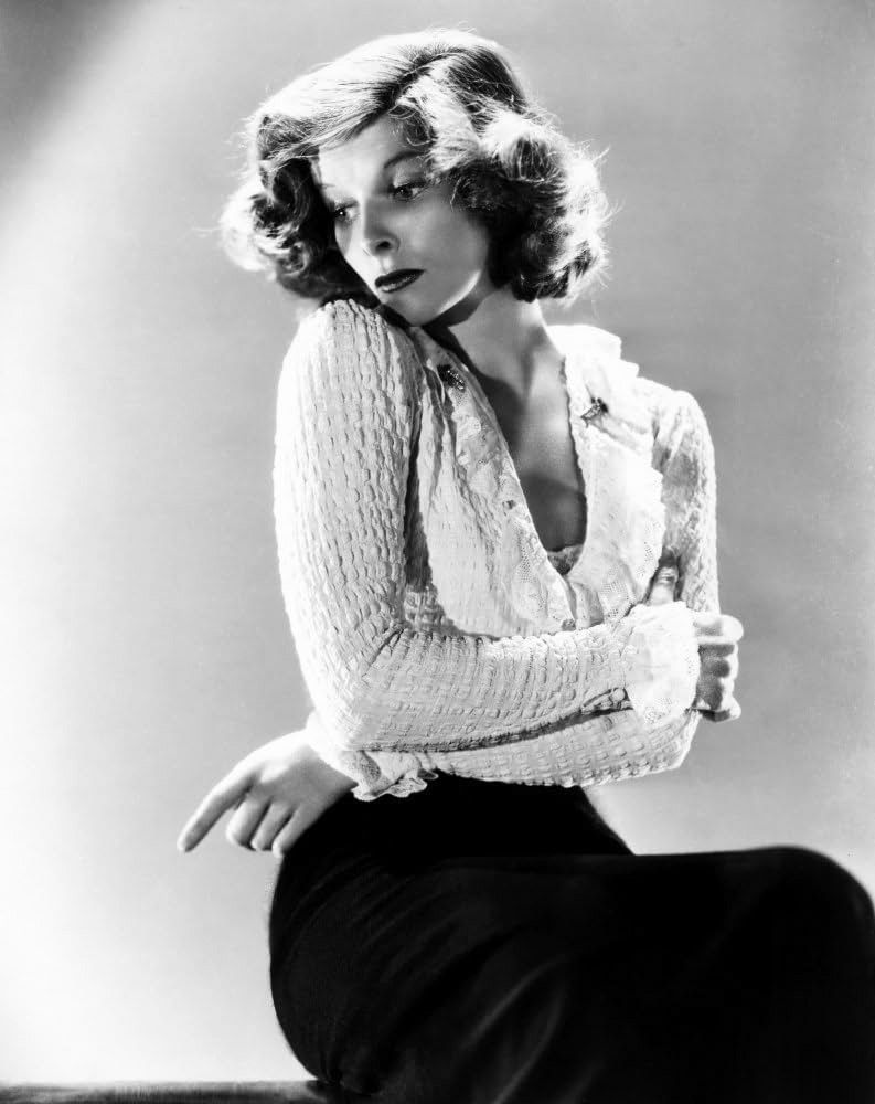 Portrait photo of young, Hollywood movie star film actress icon Katharine Hepburn in low-cut sweater with arms crossed