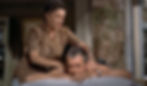 Woman giving a massage to a man lying on a bed. She's wearing a brown patterned dress. Brick wall and window in the background. Relaxed mood. Thelma Ritter massages James Jimmy Stewart as his nurse in the Alfred Hitchcock classic Hollywood film suspense movie "Rear Window"