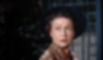 A woman in a blue hat looks to the side, appearing concerned. She wears a brown patterned blouse. Dark, blurred background suggests nighttime. Thelma Ritter plays nurse Stella in the Alfred Hitchcock classic Hollywood film suspense voyeuristic movie "Rear Window" Peeping Tom
