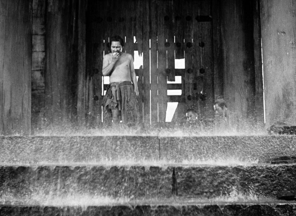 Kichijiro Ueda eats and apple as the rain falls in Akira Kurosawa's masterpiece film classic Japanese movie "Rashomon"