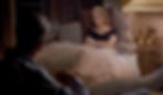 A woman in a black top sits on a sofa with crossed arms, facing a man in a dimly lit room. She appears pensive. A lamp is visible beside her. Grace Kelly in an Edith Head dress on the sofa argues with James Jimmy Stewart in the Alfred Hitchcock classic Hollywood film suspense voyeuristic movie "Rear Window" Peeping Tom