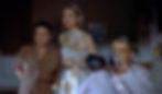 Three people in a room focus intently. A man on the right uses a camera with a long lens. One woman wears floral, another brown. Dramatic mood. Thelma Ritter, Grace Kelly, and James Jimmy Stewart with a telephoto lens watch their neigbhors in the Alfred Hitchcock classic Hollywood film suspense movie "Rear Window"