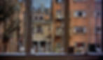 View from a window overlooking brick buildings and fire escapes. A man walks below, surrounded by urban details and a cloudy sky. Neighbors' apartments in Greenwich Village courtyard in the Alfred Hitchcock classic Hollywood film suspense movie "Rear Window" voyeurism Peeping Tom