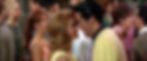A couple in a yellow and black outfit leans in closely, smiling at each other in a crowded room. A woman in pink nearby also leans in. Ann-Margret and Elvis Presley dance in the classic 1960s Elvis Presley rocking MGM movie musical "Viva Las Vegas".