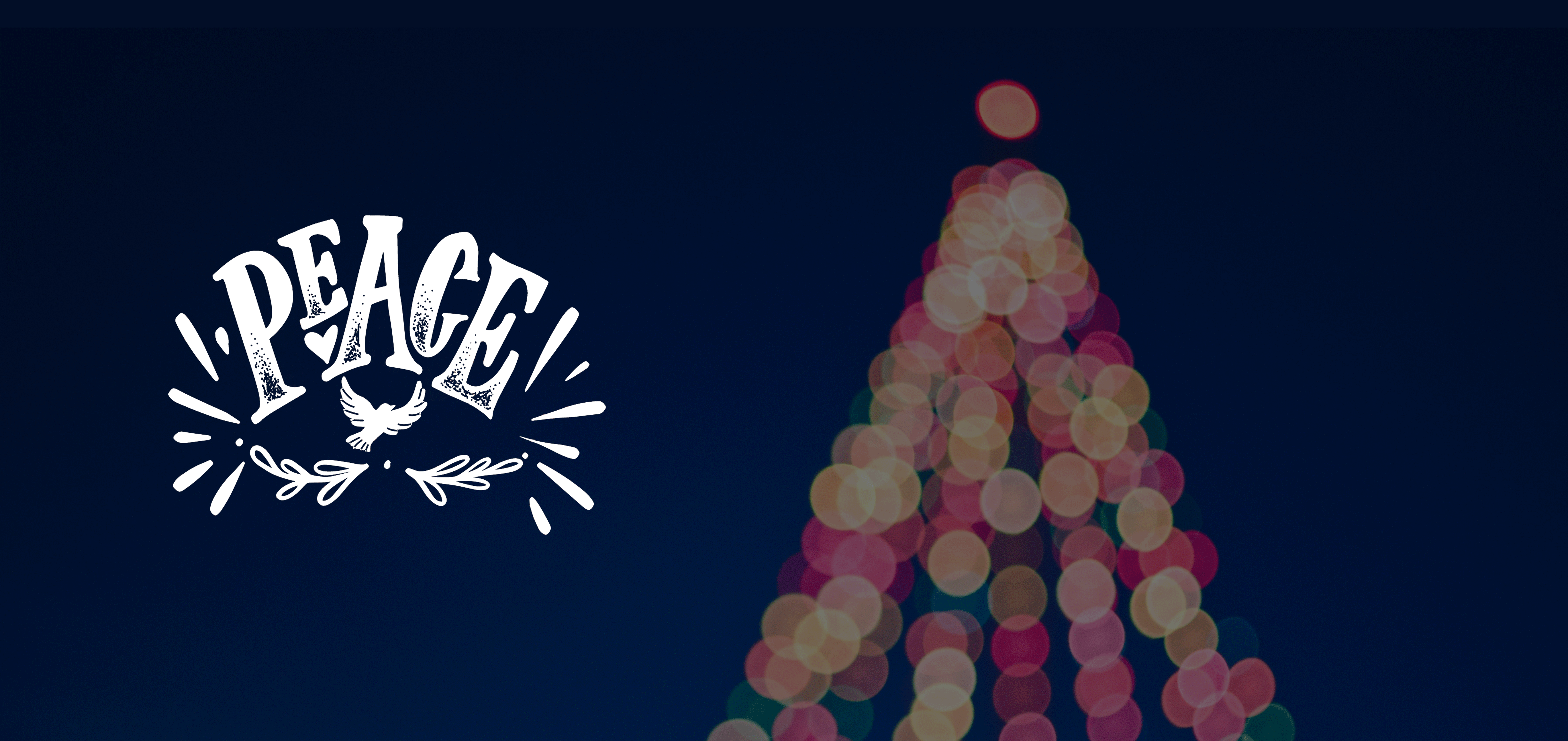 Picture of a lit up christmas tree with the word peace next to it