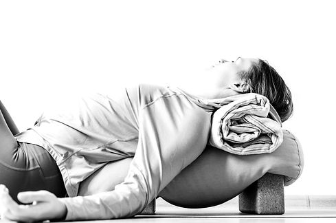 Woman doing restorative yoga with bolster, blanket and blocks_edited.jpg