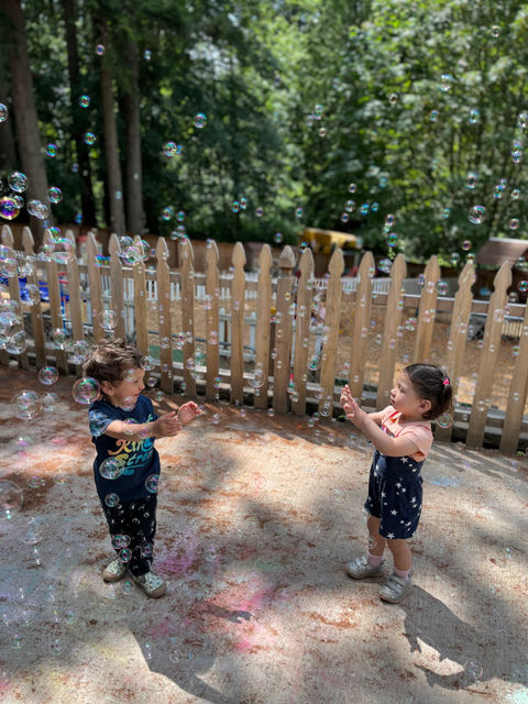 Two preschoolers playing outside on warm day.