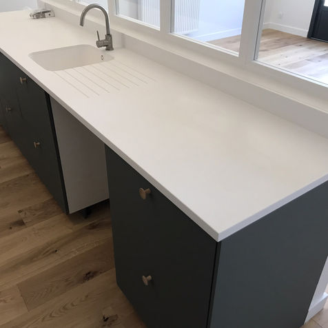 Plan de travail de cuisine sur mesure en Corian, avec évier en Corian, sur caissons indust