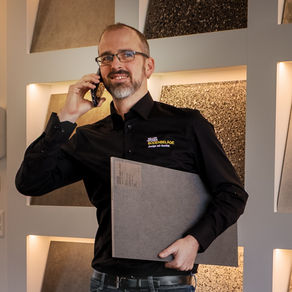 Daniel Wiser telefoniert vor Ausstellung mit Bodenbelägen
