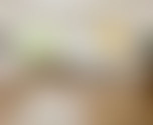 „Helles modernes Wohnzimmer mit großem Fenster, hellem Parkettboden im Chevronmuster, beigem Ecksofa, Couchtisch, Stehlampe, Zimmerpflanze und minimalistischer Wanddekoration.“