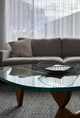 Retro living room at Caves Beach Sea Breeze holiday house with modern sofa, retro coffee table, and large sunny windows.