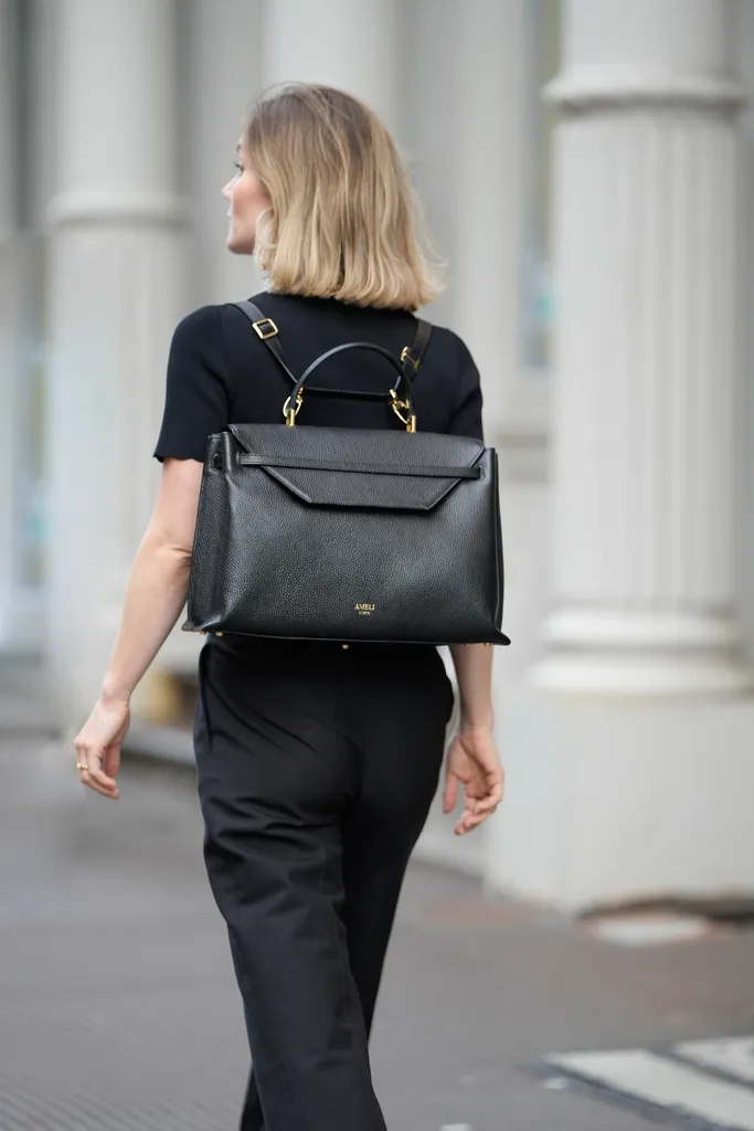 Woman wearing the AMELI Viadukt backpack in black, styled as a chic everyday piece in an urban setting.