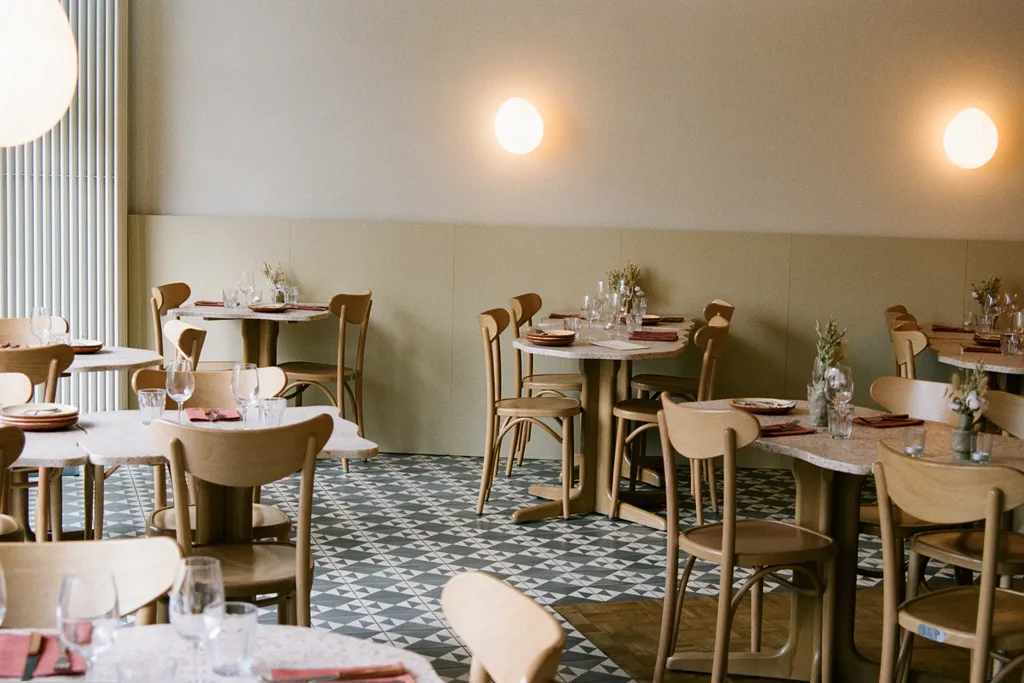 ALBA Zurich’s modern and minimalist interior with wooden chairs, tiled flooring, and cozy lighting — recommended by BYCA.