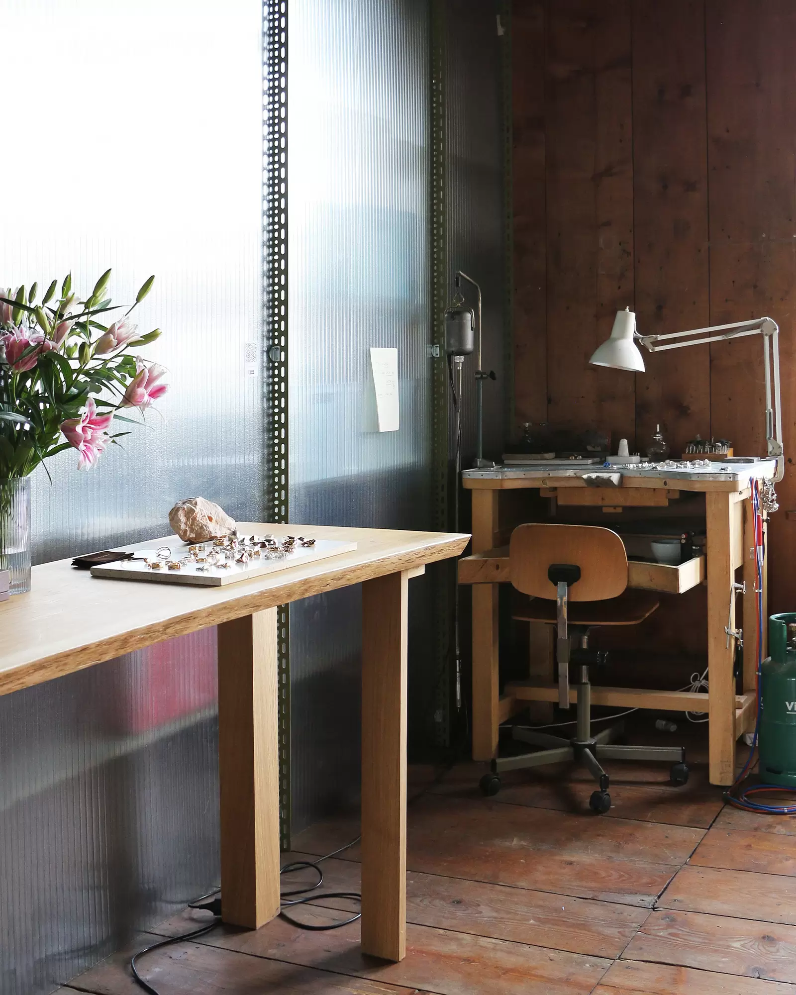 Minimalist jewelry studio in Zurich with fresh flowers and workstations, as featured in the Byca Zurich Guide for hands-on creative experiences.