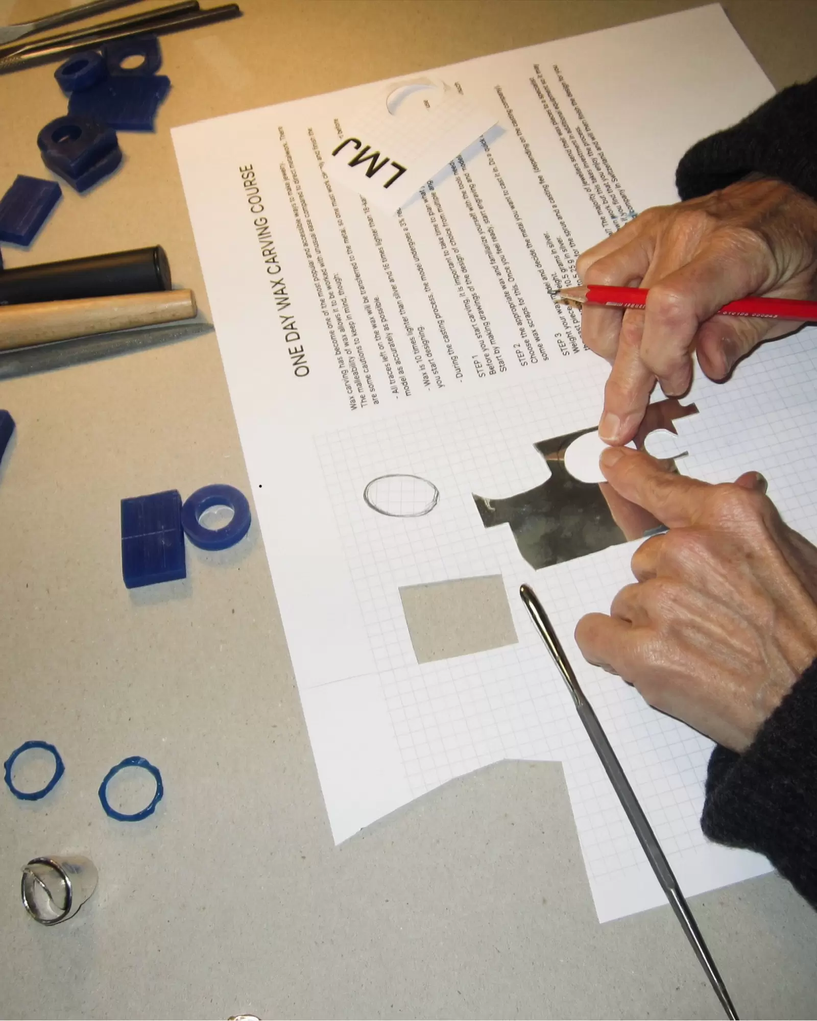 Hands sketching ring designs on paper during a wax carving course in Zurich, part of Byca’s recommended creative activities.