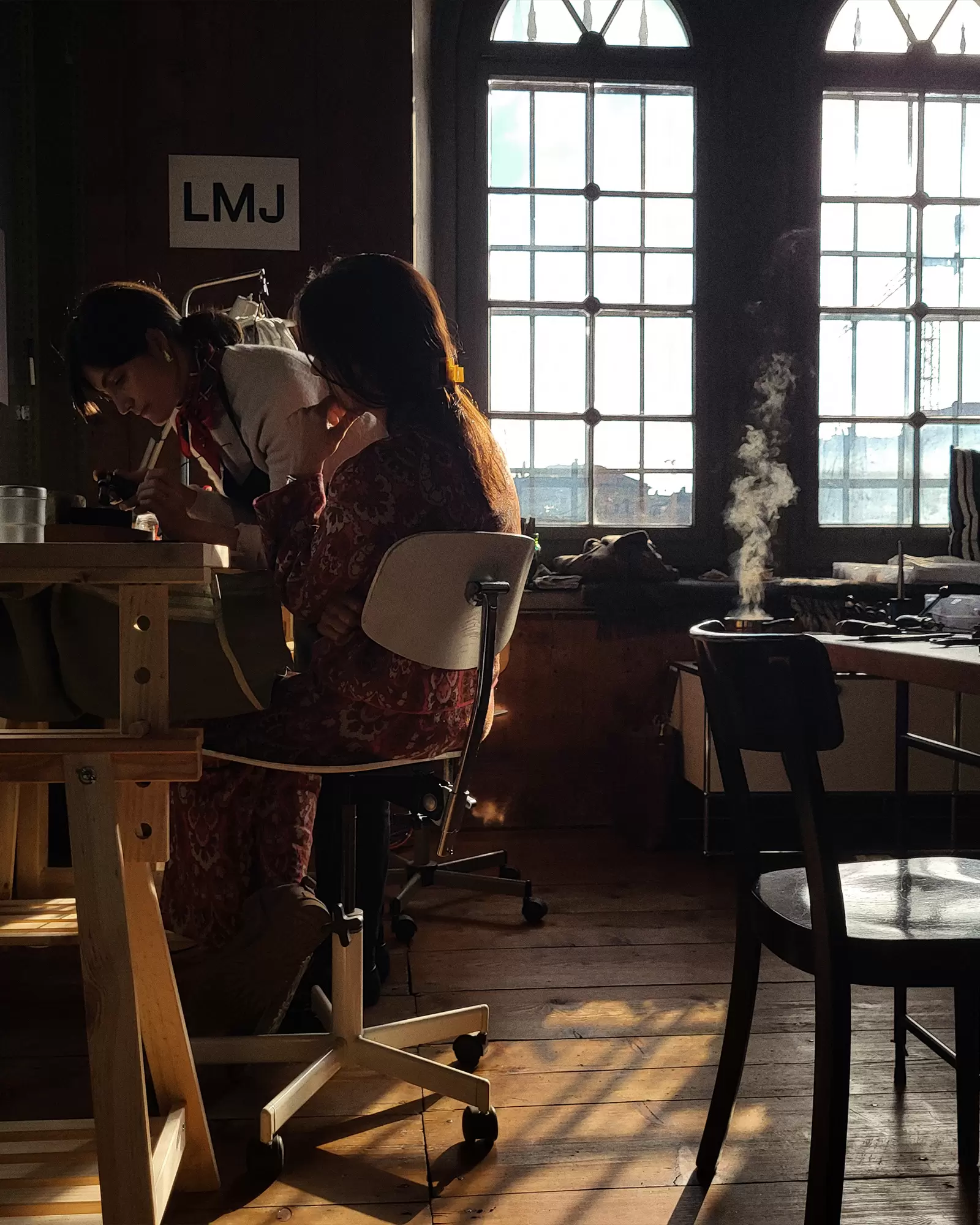 Two participants focused on creating jewelry in the golden hour light at LMJ studio in Zurich – a Byca favorite for mindful creativity.